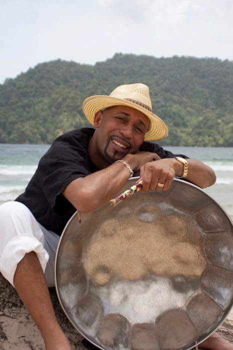 Ken "Professor" Philmore poses with his tenor pan on a beach. 